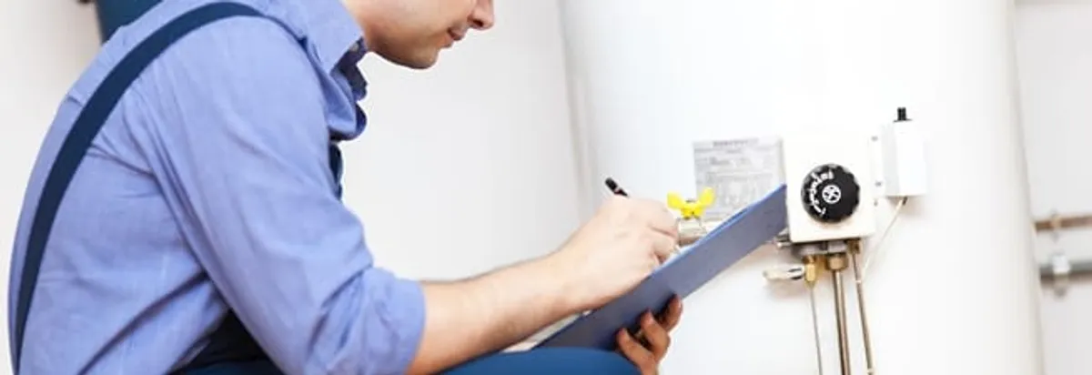 Water heater repair technician inspecting the unit and recording service notes in Syracuse, NY